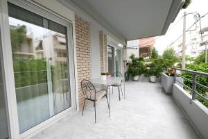 a patio with a table and chairs on a balcony at Lux 1-bedroom condo-L&L Refuge in Athens