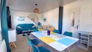 a living room with a table and blue chairs at Baie de somme in Abbeville