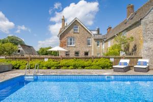 a swimming pool in front of a house at Overtown Manor Bed and Breakfast in Swindon