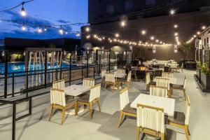 丹佛DoubleTree by Hilton Denver Cherry Creek, CO的一个带桌椅的户外庭院和一个游泳池