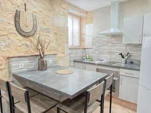 a kitchen with a table and chairs in a kitchen at Confortable T2 - 1 à 4 pers- WIFI in Béguey