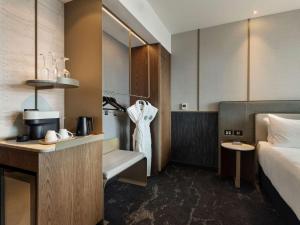 a hotel room with a bed and a kitchen at Pullman Auckland Airport in Auckland