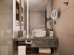 a bathroom with a sink and a counter at Pullman Auckland Airport in Auckland