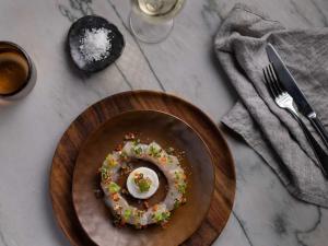 a plate with a doughnut with a fried egg on it at Pullman Auckland Airport in Auckland