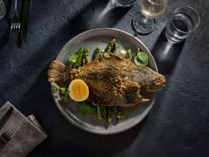 a plate of food with a fish on a table at Pullman Auckland Airport in Auckland
