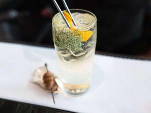 a drink sitting on a table with a bug in it at Pullman Auckland Airport in Auckland