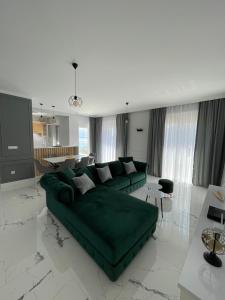 a living room with a green couch in the middle at Villa Le Grand Bleu in Đenovići