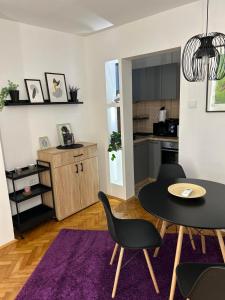 a living room with a table and chairs and a kitchen at Martina Lux in Belgrade