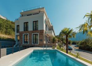 a house with a swimming pool in front of a building at S Palace Apartment in Kotor