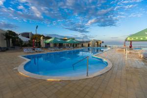 a large swimming pool with chairs and umbrellas at Zhagalau Resort in Aktau