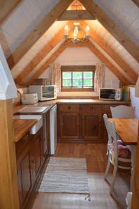 a kitchen with wooden cabinets and a table in a room at Silver Birch Cabin, Bulbury Farm in Lytchett Matravers