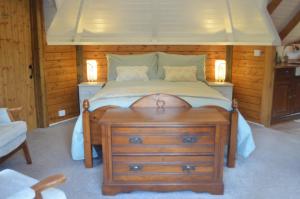 a bedroom with a bed with a wooden head board at Silver Birch Cabin, Bulbury Farm in Lytchett Matravers