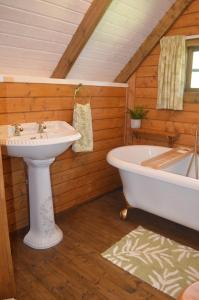 a bathroom with a sink and a bath tub at Silver Birch Cabin, Bulbury Farm in Lytchett Matravers +6 photos