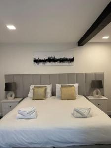 a bedroom with a large white bed with two towels on it at City Centre Former Coach House in Oxford +12 photos