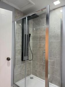 a shower with a glass door in a bathroom at City Centre Former Coach House in Oxford