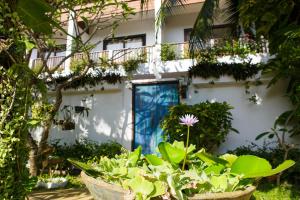 a building with a blue door and some plants at Greenlight Fisherman's Village Resort & Café in Koh Samui 