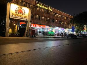 a city street at night with a building with neon signs at Hotel Maharana Inn Chembur in Mumbai