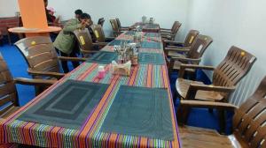 a long table in a restaurant with people sitting around it at Peace Cottages Pangong Ladakh by LexStays in Meruk
