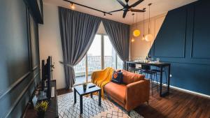 クアラルンプールにあるUNA Serviced Apartment by manatidurのソファとテーブルとキッチンのあるリビングルーム