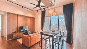 クアラルンプールにあるUNA Serviced Apartment by manatidurのリビングルーム(ダイニングテーブル、ソファ付)