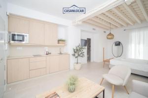 a kitchen and living room with a couch and a table at Sanlucar Centro - Apartamento 1 in Sanlúcar de Barrameda