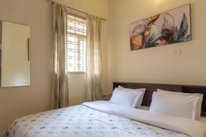 Un dormitorio con dos camas y una ventana. en The Urban Grandeur 1, en Guwahati