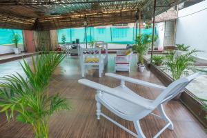 Una oficina con una silla blanca, mesas y plantas. en The Urban Grandeur 1, en Guwahati
