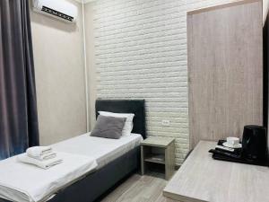 een kleine kamer met 2 bedden en een tafel bij Hotel Shosh Boutique in Tasjkent +44 foto's