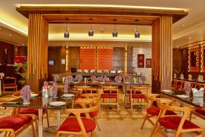 a restaurant with tables and chairs in a room at HOTEL NILADRI PREMIUM in Puri