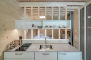 a kitchen with white cabinets and a sink at Apartment am Camping Dornbirn - 212 Salzbödenkopf in Dornbirn