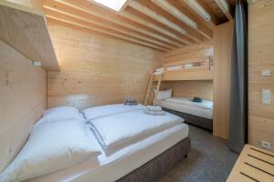 two beds in a wooden room with two bunk beds at Apartment am Camping Dornbirn - 211 Hangspitze in Dornbirn