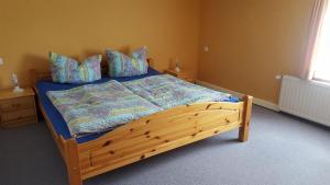a bedroom with a wooden bed with blue sheets and pillows at Haus Elbtalblick in Kurort Rathen