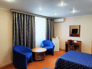 a hotel room with a bed and a table and chairs at Жеруйык Отель in Aktau