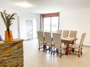 a dining room with a wooden table and chairs at Maison de campagne paisible in La Ménière