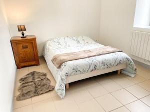 a small bedroom with a bed and a night stand at Maison de campagne paisible in La Mesniere