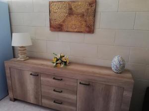 a wooden cabinet with a lamp and a vase on it at La Casa di Giulia in Otranto