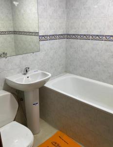 a bathroom with a sink and a tub and a toilet at Résidence el fassi in Fès