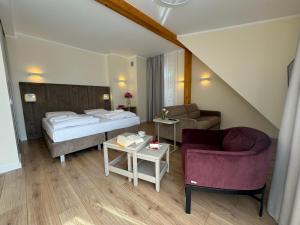 una camera d'albergo con un letto e un divano di H Villa Herkules a Świnoujście