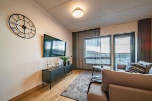 een woonkamer met een bank en een klok aan de muur bij Ski Chalet C27 Levi Center incl 2 ski passes by Aavalevi in Levi