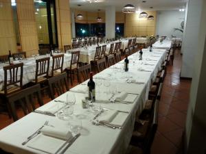 una fila de mesas en un restaurante con botellas de vino en Hotel Toscana, en Figline Valdarno