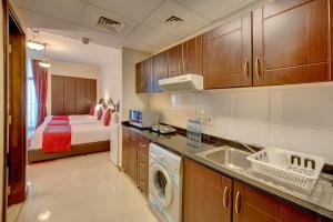 eine Küche mit Spüle und ein Bett in einem Zimmer in der Unterkunft City Stay Premium Hotel Apartments in Dubai