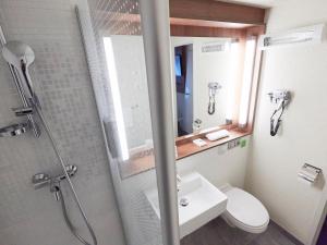 a bathroom with a shower and a toilet and a sink at Campanile Tours Sud - Chambray-Les-Tours in Chambray-lès-Tours +28 photos
