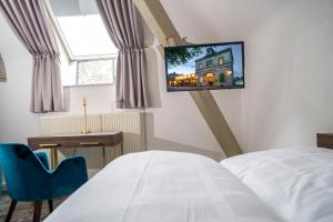 una camera da letto con un letto e una TV a parete di Hotel am Prinzengarten, inklusive AlbCard a Sigmaringen