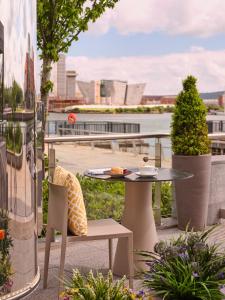 a table and chair on a balcony with a view of a city at AC Hotel by Marriott Belfast in Belfast