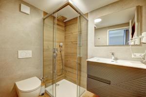 a bathroom with a shower and a toilet and a sink at MK Apartments in Aulendorf