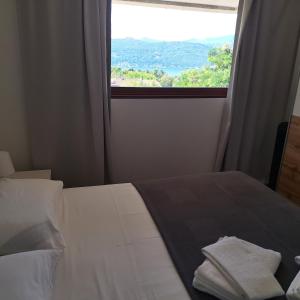 a bedroom with a bed with a large window at In Cima al Bosco in Leggiuno