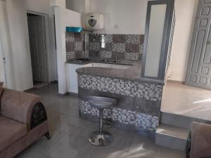 a kitchen with a counter with a sink and a stool at appartement Cristiana 6 Midoun in Midoun