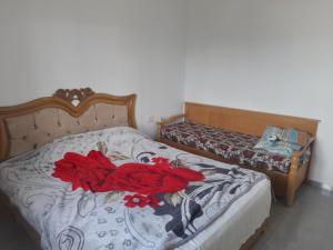 a bedroom with two beds with red roses on it at appartement Cristiana 6 Midoun in Midoun