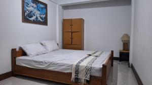 SengkolにあるBougenville Village Houseのベッドルーム1室(ベッド1台、キャビネット付)