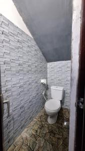 SengkolにあるBougenville Village Houseのレンガの壁のバスルーム(トイレ付)